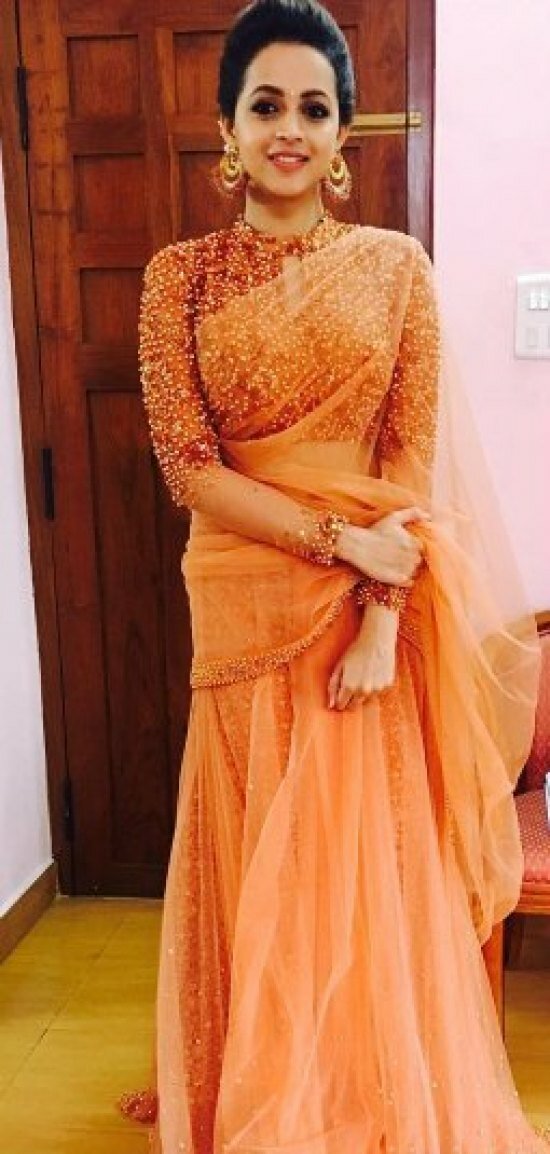 Pretty Bhavana chose an orange-gold glittering saree and teamed it with Amrapali jewellery