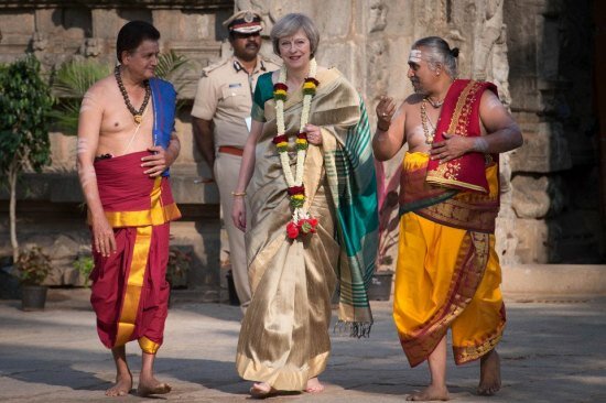Temple priests accompany a saree-clad British PM