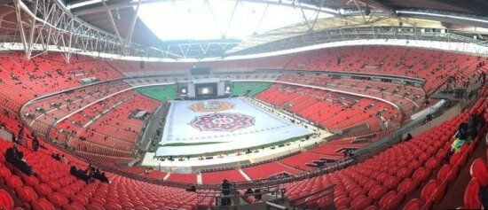 The elaborate and colourful Rangoli creation in the middle of Wembley stadium as part of giving Modi an Indian welcome in the UK. Also, enthusiastic UK Indians already taking seats ready for the event to start